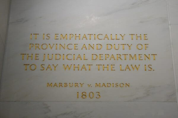 Marble tile with the phrase "it is emphatically the province and duty of the judicial department to say what the law is." above "Marbury v. Madison 1803" etched in gold.